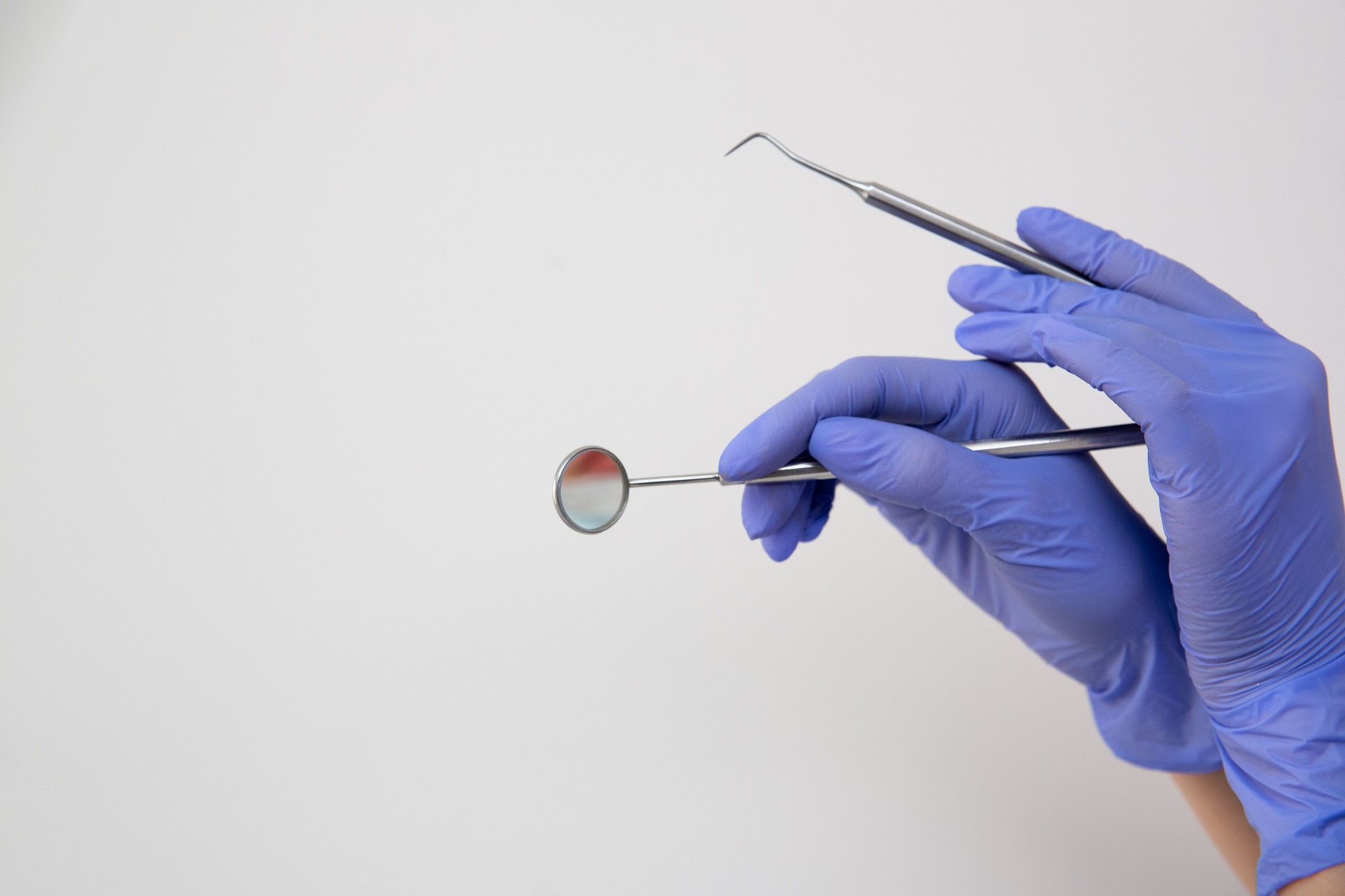 Specchietto e sonda odontoiatrica nelle mani di un professionista